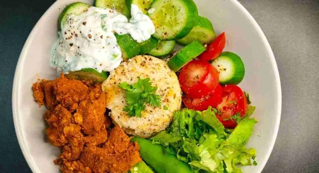 Yogurt rice lunch bowl with cucumbers herbs and crunchy vegetables for texture contrast
